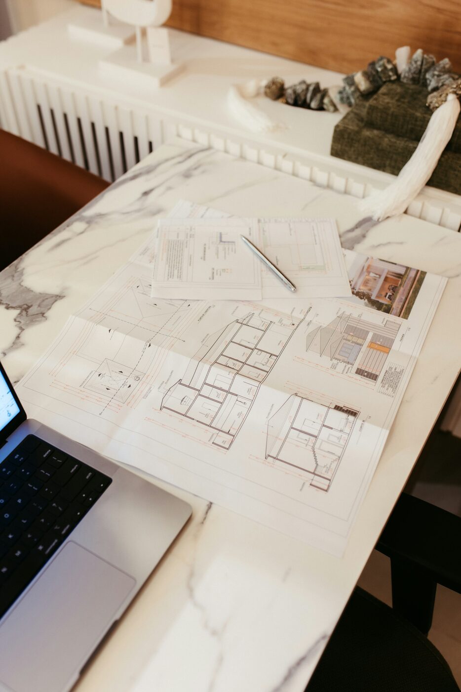 Architekturpläne und Laptop auf einem Arbeitstisch